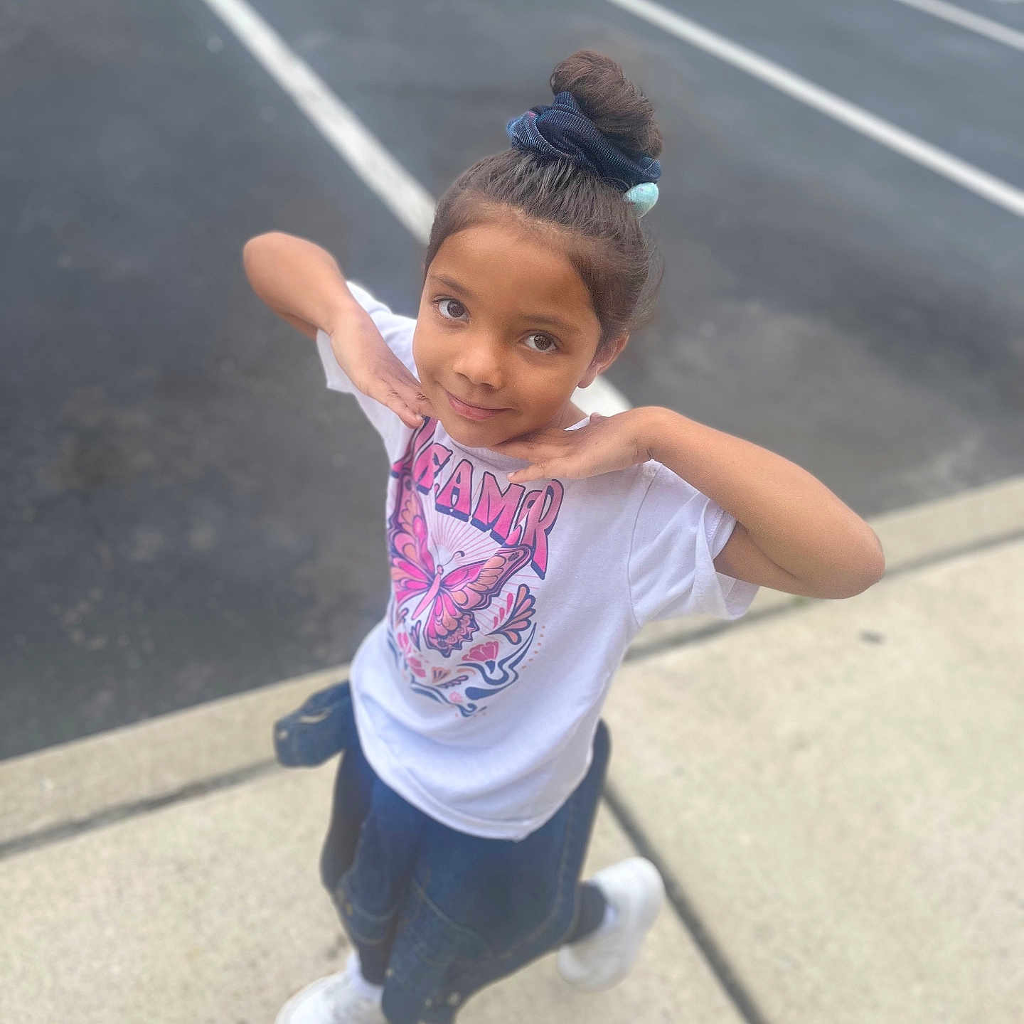 Serenity is registered to the contest to win money with this photo: casual_clothing, child, denim_jacket, fashion, girl, hair_bun, happy, outdoor, parking_lot, playful, portrait, posing, scrunchie, sidewalk, smiling, standing, tshirt, urban, white_shoes, young