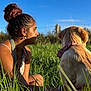 woman, dog, golden_retriever, grass, outdoor, sunlight, blue_sky, bandana, nature, pet, casual_clothing, bracelet, earrings, tattoo, side_profile, summer, relaxation, friendship, field, sunset
