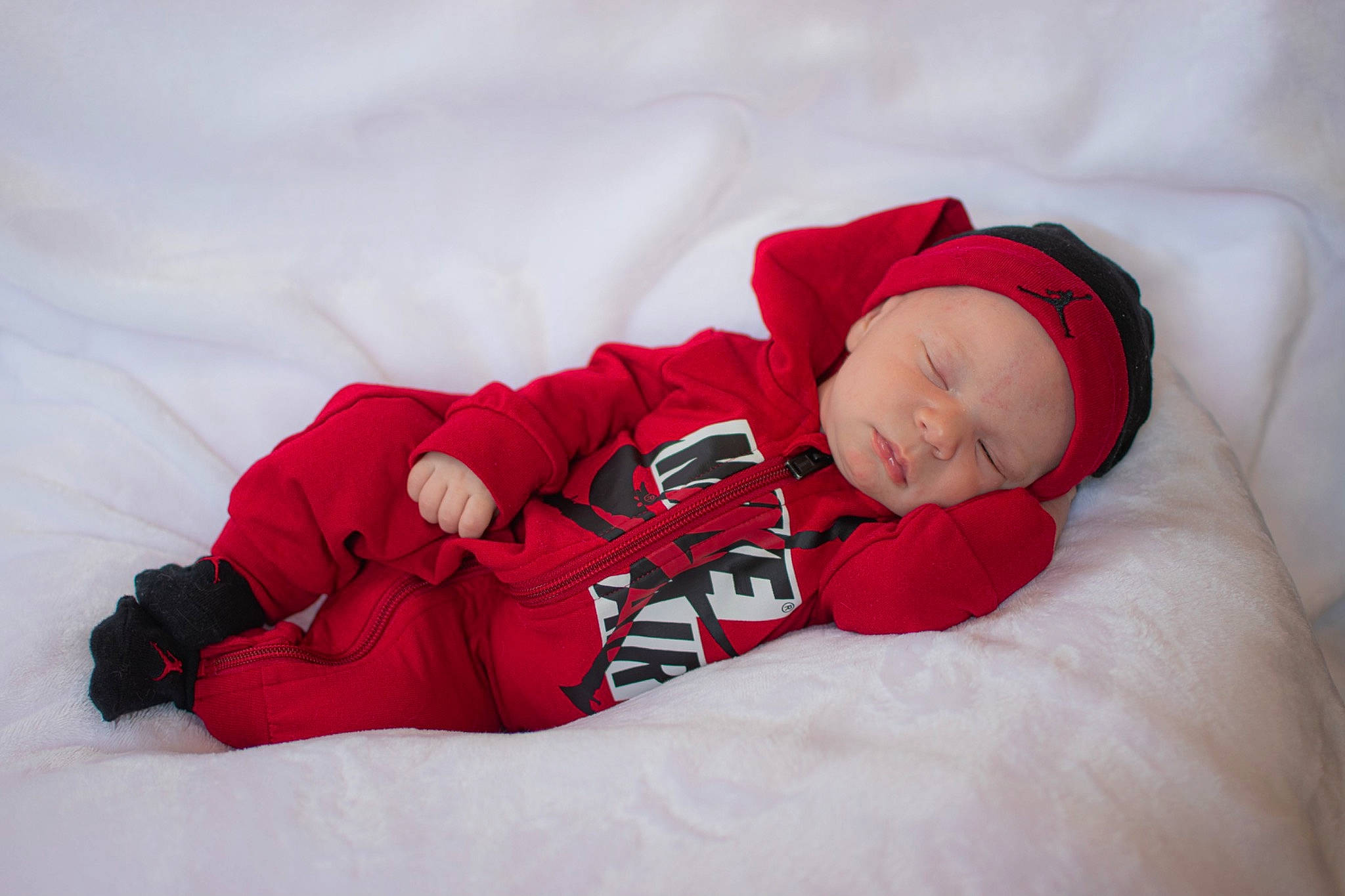 Jahseh joined the competition — help win amazing prizes! baby, baby_sleeping, baby_toddler_clothing, beanie, cap, carmine, child, comfort, face, fur, happy, headwear, leg, linens, magenta, person, sitting, sleeve, snow, textile