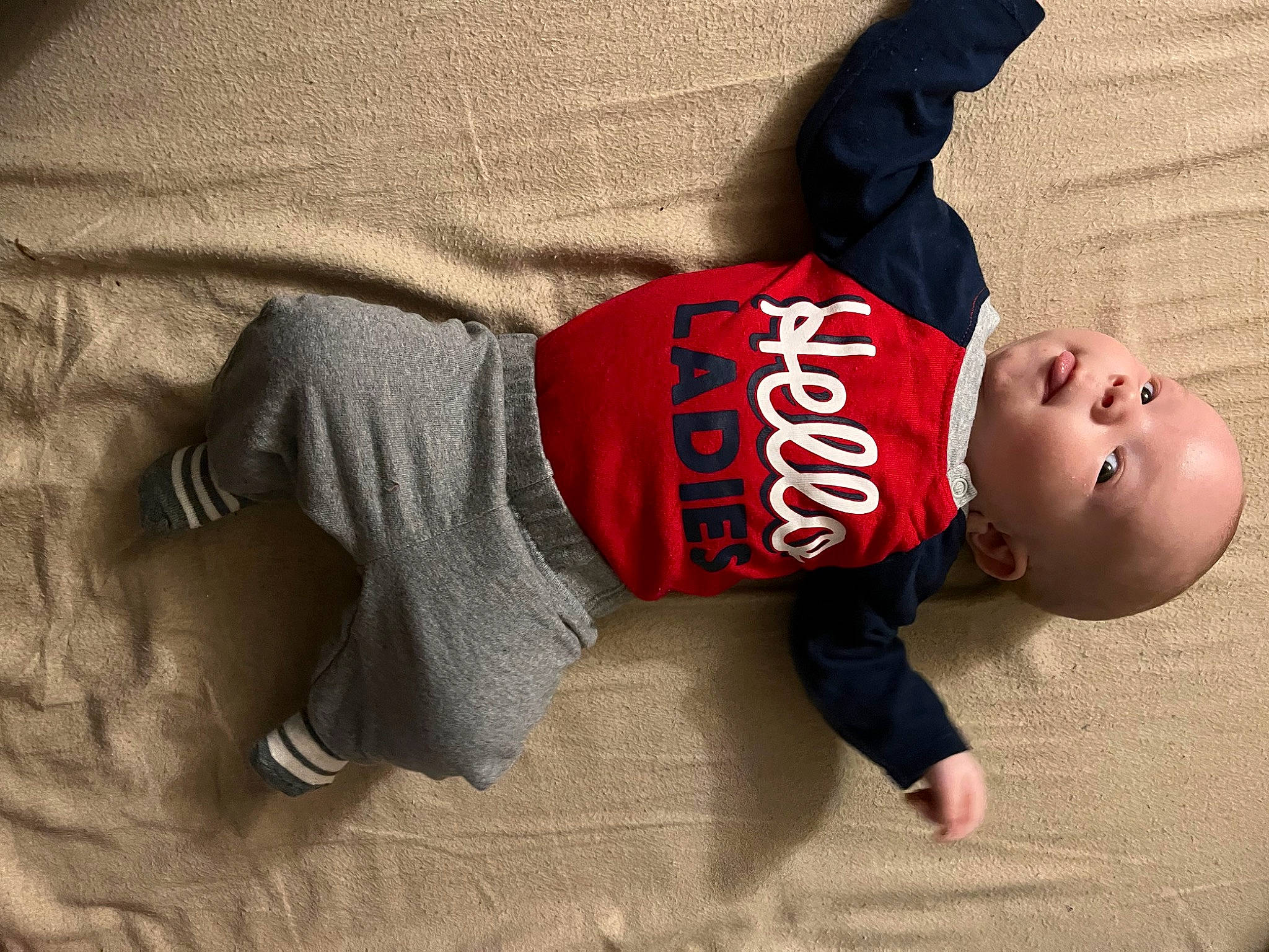 Jahseh is registered to the contest to win money with this photo: arm, baby, baby_toddler_clothing, comfort, elbow, finger, floor, flooring, hand, headgear, human_body, human_leg, knee, leg, person, shoulder, sleeve, sportswear, t_shirt, toddler