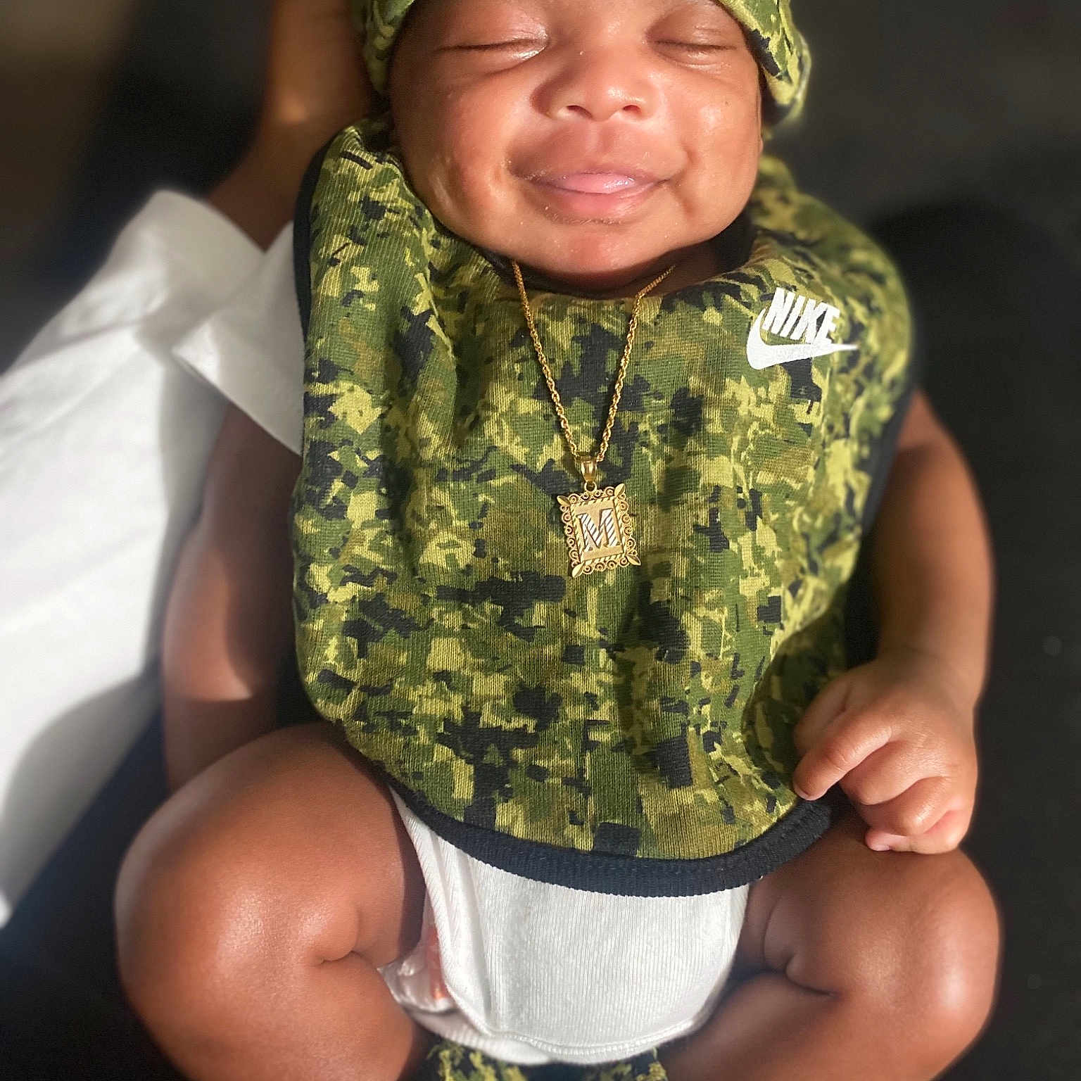 Majarhi is registered to the contest to win money with this photo: arm, baby, baby_toddler_clothing, cap, child, fun, gesture, grass, hand, happy, headgear, human_body, military_camouflage, photograph, sleeve, smile, thigh, thumb, toddler, trunk