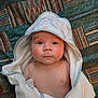Jasper is registered to the contest to win money with this photo: baby, infant, hooded_towel, blanket, patterned_blanket, face, skin, eyes, expression, cute, child, newborn, indoors, portrait, soft_texture, cute_baby, wrapped, looking_up, resting, comfort