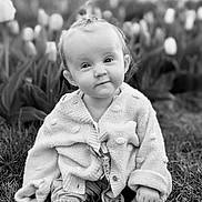 Esmae joined the competition — help win amazing prizes! baby, child, grass, tulips, flower, knitwear, cardigan, cute, smile, outdoor, nature, portrait, sitting, infant, cozy, young, face, head, expression, black_and_white