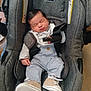 baby, infant, newborn, car_seat, seat_belt, buckle, sleeping, closed_eyes, shoes, sneakers, clothing, head, face, hair, harness, cushion, fabric, brand_evenflo, indoor, portrait