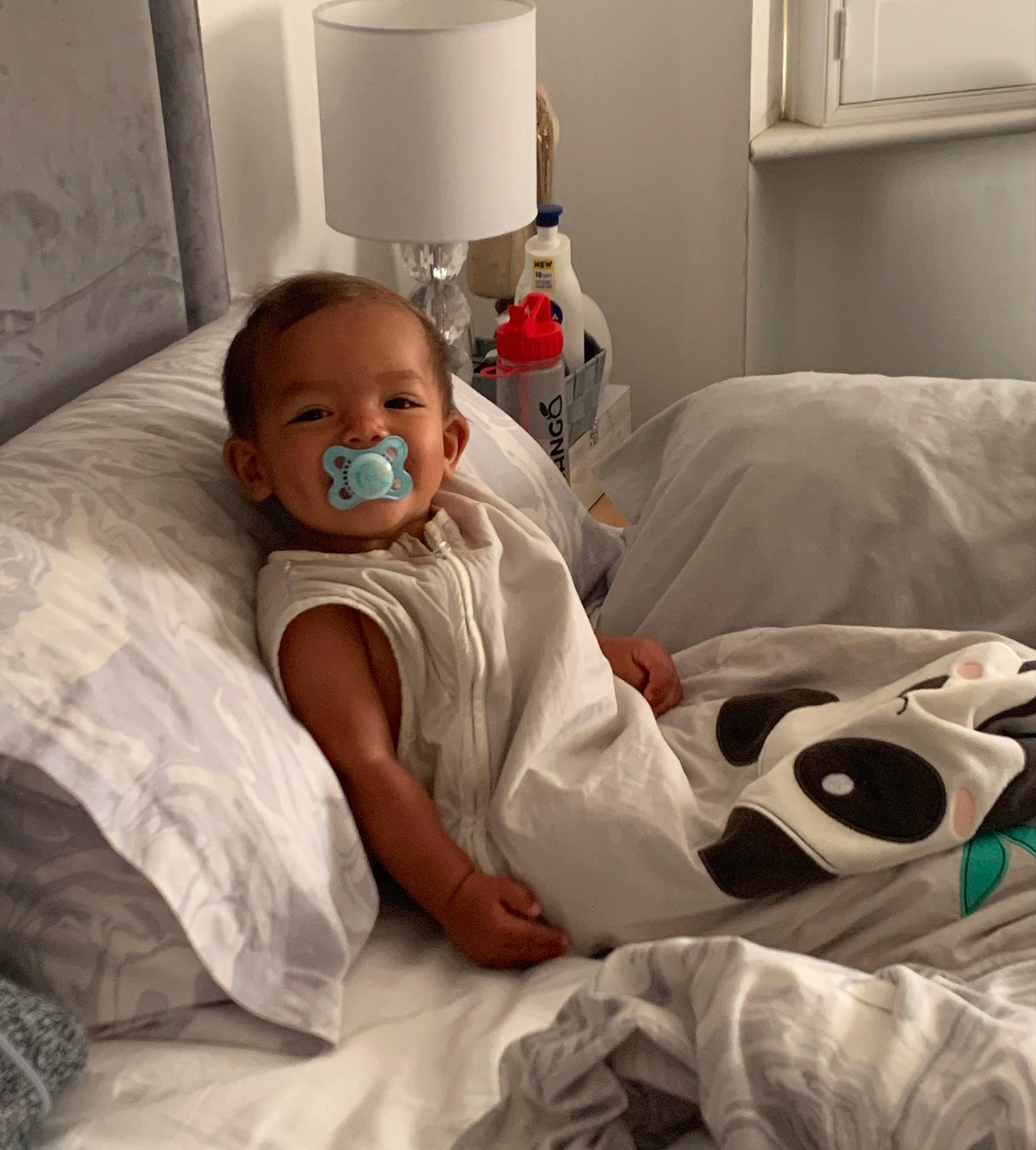 Carmen is registered to the contest to win money with this photo: baby, bed_sheet, bedding, bedroom, child, comfort, event, eye, hospital, human_body, lamp, linens, mouth, person, pillow, room, sitting, textile, throw_pillow, toddler