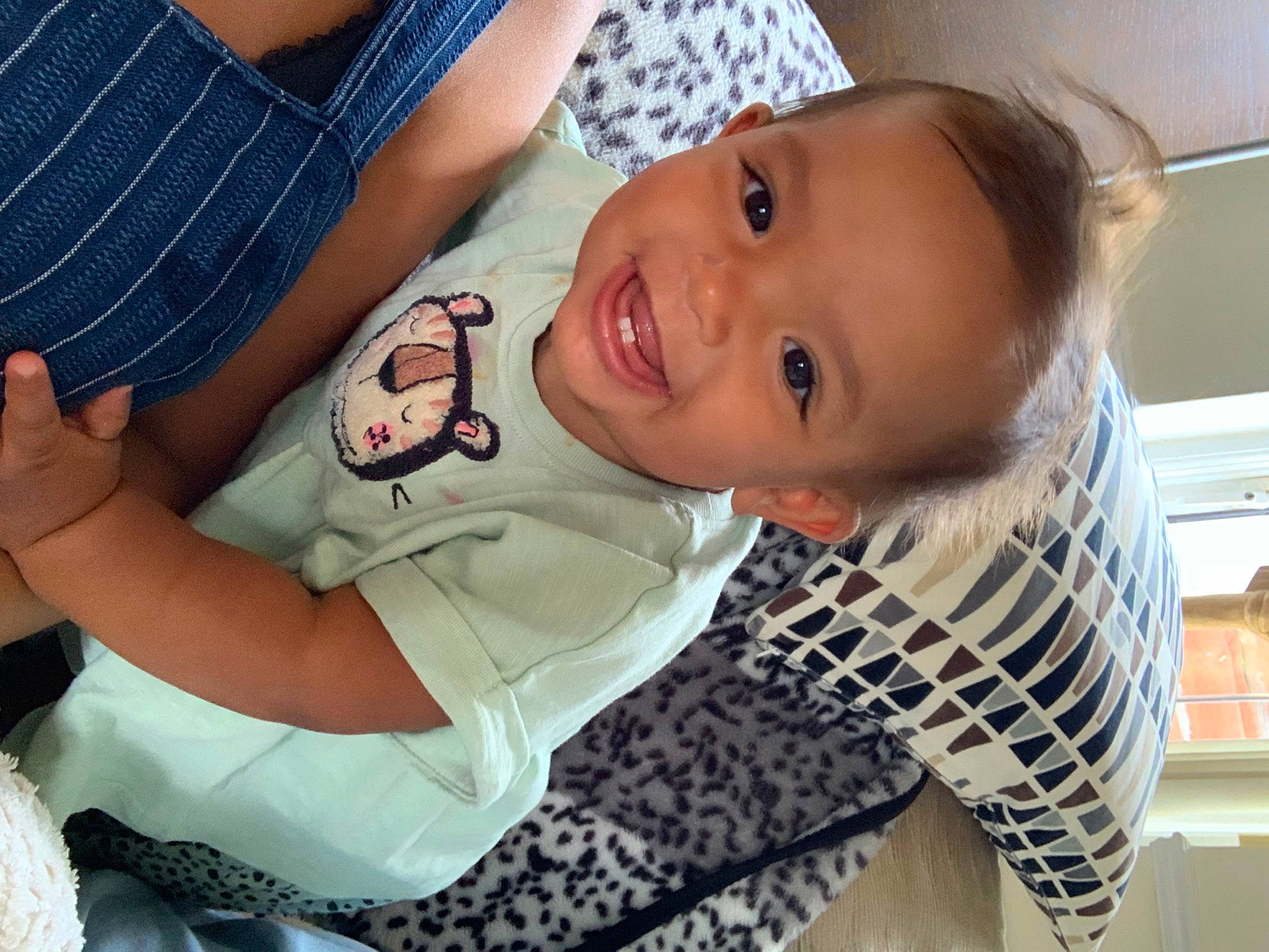 Carmen is registered to the contest to win money with this photo: arm, baby, baby_toddler_clothing, cheek, child, clothing, elbow, fun, gesture, hand, happy, joy, mouth, nose, person, sitting, skin, sleeve, smile, t_shirt