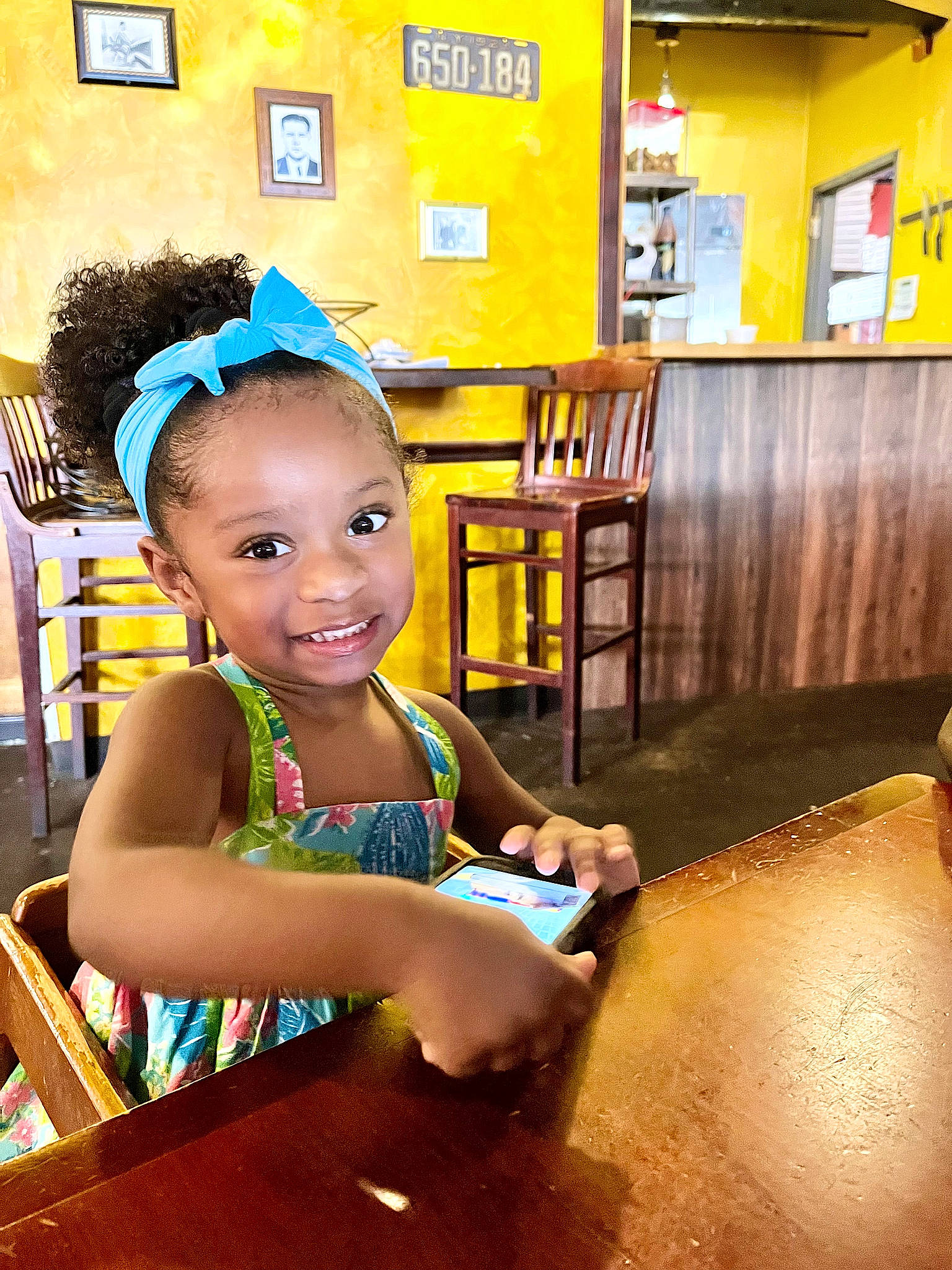 Lilee is registered to the contest to win money with this photo: audio_equipment, chair, child, flash_photography, flooring, fun, hairstyle, happy, joy, leisure, person, picture_frame, room, sitting, smile, t_shirt, toddler, vacation, wood