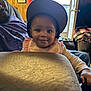 Mo Zyiah joined the competition — help win amazing prizes! baby, child, smile, cap, indoor, man, glasses, window, cushion, furniture, wood_paneling, blanket, person, portrait, seated, happy, home, casual, face, infant