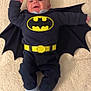 Timéo a rejoint le concours — aidez-le/la à gagner de superbes lots ! baby, batman_costume, cape, smiling, infant, blanket, superhero, child, cute, lying_down, black_clothing, yellow_belt, footwear, happy, portrait, indoor, person, costume, fingers, head
