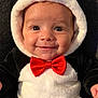 Timéo participe au concours pour gagner de l'argent avec cette photo : baby, smile, penguin_costume, red_bow_tie, plush, cute, infant, child, face, head, costume, black_and_white, yellow_feet, happy, sitting, soft_texture, indoors, portrait, clothing, adorable