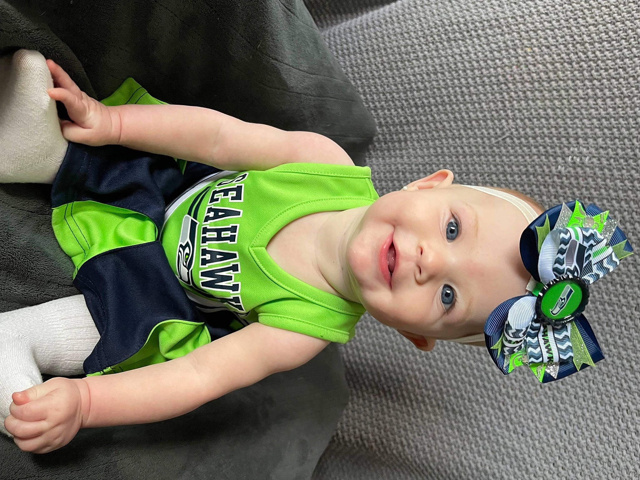 Aspen is registered to the contest to win money with this photo: abdomen, baby, baby_products, baby_toddler_clothing, chest, child, comfort, elbow, flooring, grass, head, human_leg, knee, pattern, person, sitting, sleeve, sportswear, t_shirt, thigh