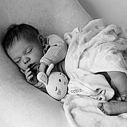 Elise is registered to the contest to win money with this photo: baby, sleeping, blanket, soft_toy, monochrome, infant, cozy, peaceful, cute, child, portrait, rest, toddler, fabric, comfort, relaxation, indoor, face, hand, foot