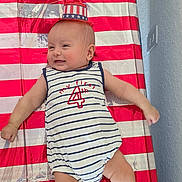 Liam Alexander joined the competition — help win amazing prizes! baby, infant, child, smiling, patriotic, american_flag, fourth_of_july, red_white_blue, striped_outfit, hat, flower_arrangement, booties, lying_down, portrait, indoor, celebration, holiday, playmat, happy, photography