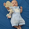 baby, infant, child, portrait, milestone, three_months, blue_blanket, striped_outfit, bow_tie, suspenders, plush_toy, cloud_sign, smiling, lying_down, indoor, close_up, adorable, celebration, baby_clothing, photography