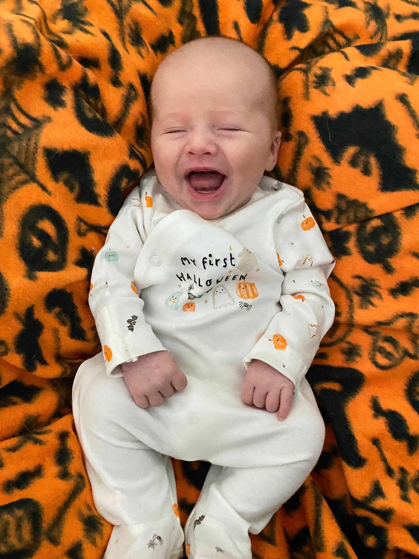 Niklaus joined the competition — help win amazing prizes! baby, laughing, infant, halloween, costume, blanket, orange, black, pattern, smile, happy, cute, clothing, person, lying_down, celebration, festive, holiday, face, infant_clothing
