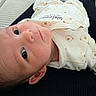 baby, newborn, infant, face, eyes, onesie, clothing, cute, portrait, lying_down, indoors, soft_lighting, baby_garment, infant_face, child, toddler, peaceful, closeup, head, skin