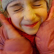 Luna participe au concours pour gagner de l'argent avec cette photo : beanie, candid, child, close_up, eyes_closed, face, freckles, gloves, indoor, kid, knit_hat, pink_gloves, playful_expression, portrait, rosy_cheeks, scarf, smile, striped_hat, winter_clothing, winter_coat