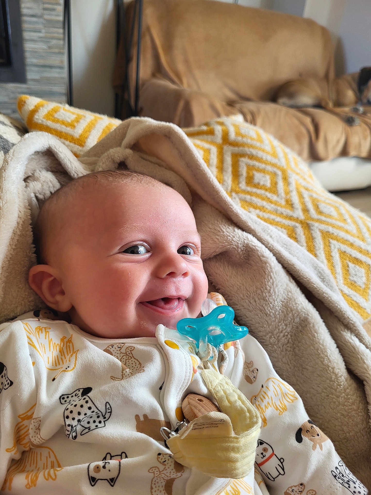 Louis a rejoint le concours — aidez-le/la à gagner de superbes lots ! baby, smiling, pacifier, blanket, onesie, animal_print, indoor, cozy, child, cute, infant, happy, face, clothing, fabric, person, portrait, young_child, home, comfort