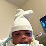 Kalani joined the competition — help win amazing prizes! newborn, baby, infant, portrait, face, eyes, hat, white_hat, blanket, swaddled, clothing, indoors, home, couch, television, cozy, close_up, sitting, awake, family