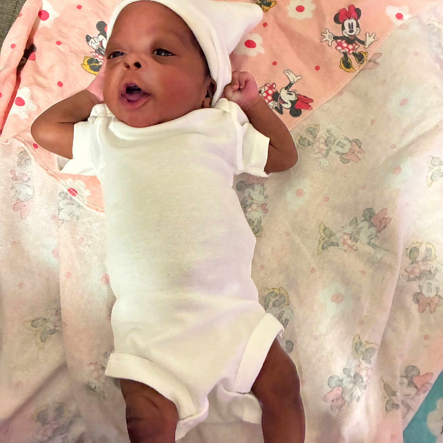 Kalani joined the competition — help win amazing prizes! newborn, baby, infant, child, portrait, lying_down, white_outfit, white_hat, socks, blanket, pink_blanket, blue_blanket, minnie_mouse, cartoon_pattern, indoor, cozy, adorable, awake, smiling, photography
