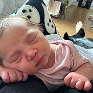 Aurora is registered to the contest to win money with this photo: baby, sleeping, infant, pink_clothing, hand, face, blanket, dog, pet, resting, cozy, indoor, wooden_floor, foot, person, relaxation, cute, newborn, home, soft_light