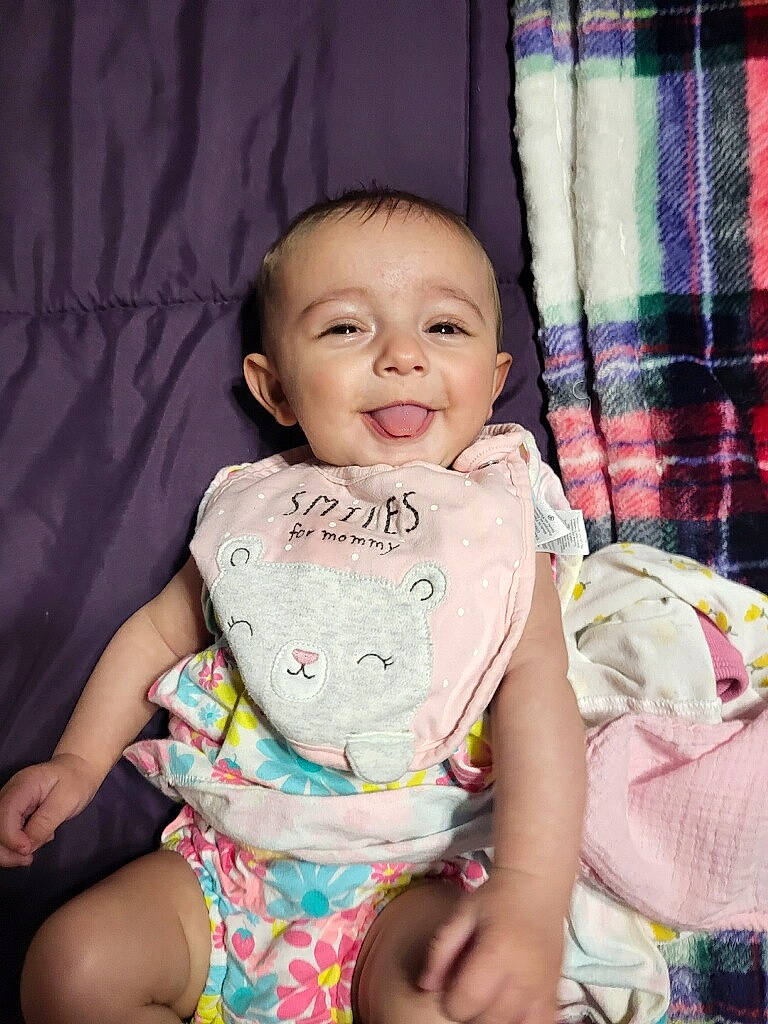 Addilynn is registered to the contest to win money with this photo: baby, baby_toddler_clothing, cheek, child, eye, finger, fun, hairstyle, happy, iris, organ, person, pink, sitting, skin, sleeve, smile, t_shirt, tartan, thigh