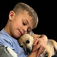 Franklin joined the competition — help win amazing prizes! affection, animal, black_background, bond, boy, casual_clothing, child, closeup, comfort, cute, dog, hug, human, indoor, love, pet, portrait, short_hair, small_dog, tan_dog