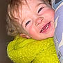 Thalya a rejoint le concours — aidez-le/la à gagner de superbes lots ! toddler, child, smile, yellow_jacket, fuzzy_clothing, curly_hair, face, teeth, happy, close_up, indoor, pillow, pattern, cozy, cute, person, portrait, baby, skin, eyelashes