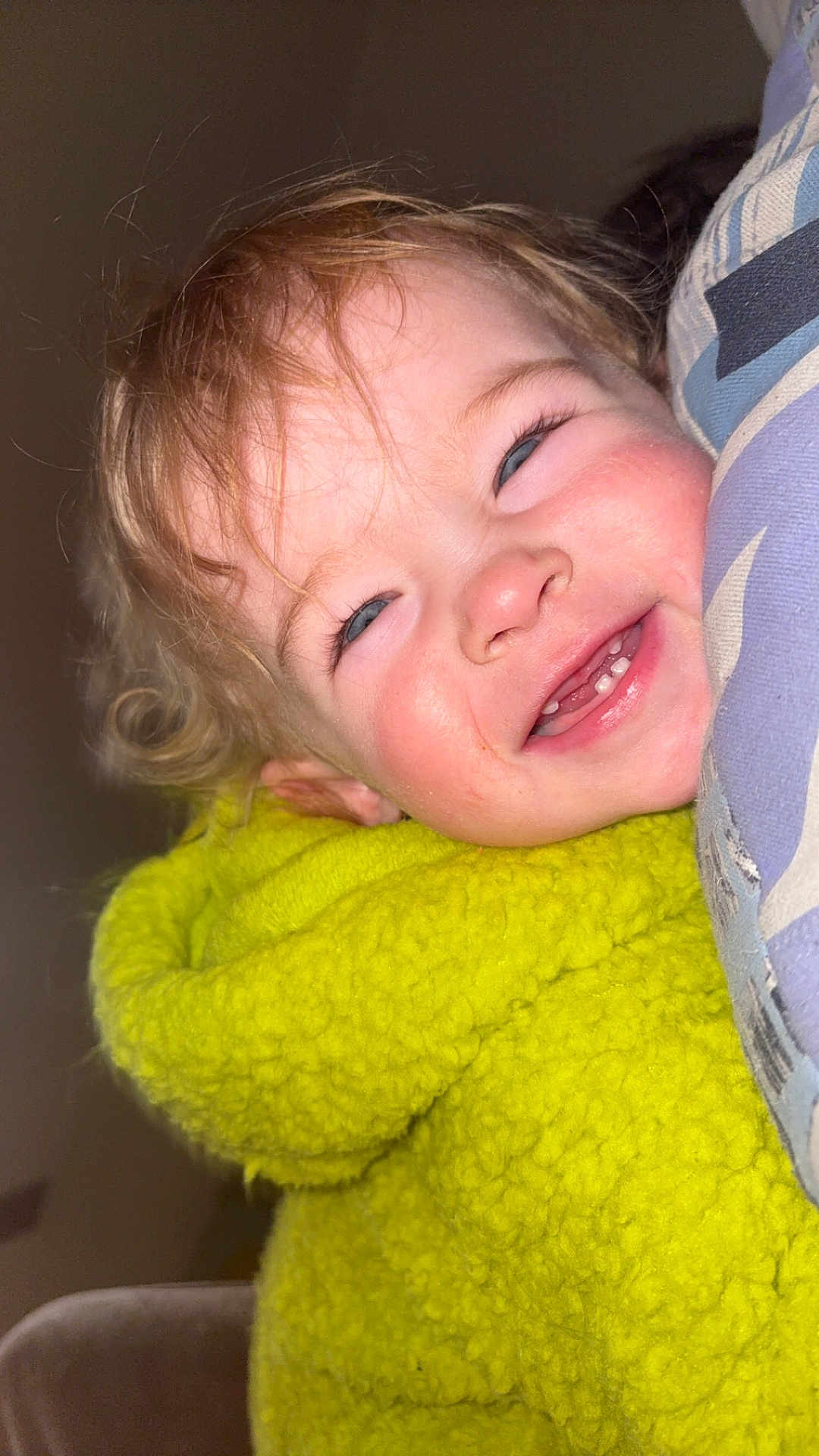 Thalya a rejoint le concours — aidez-le/la à gagner de superbes lots ! toddler, child, smile, yellow_jacket, fuzzy_clothing, curly_hair, face, teeth, happy, close_up, indoor, pillow, pattern, cozy, cute, person, portrait, baby, skin, eyelashes