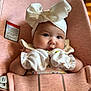 baby, infant, mittens, headband, bow, babybjorn, carrier, pink, clothing, cute, face, portrait, child, seated, indoor, soft, adorable, young, expression, closeup