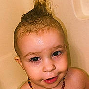 Sebastian joined the competition — help win amazing prizes! toddler, child, bathtub, water, wet_hair, mohawk, necklace, beads, smiling, face, skin, indoors, bath, cute, playful, young_child, portrait, head, shoulders, happy