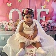 Layana is registered to the contest to win money with this photo: baby, child, dress, flower_headband, high_chair, balloons, pink, gold, butterflies, celebration, birthday, one_year, blanket, indoor, decorations, person, cute, festive, smiling, portrait