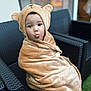 bear_hood, blanket, child, cozy, cute, expression, face, furniture, fuzzy, indoors, kid, playful, portrait, sitting, smile, soft, tongue_out, wicker_chair, wrapped, young_child