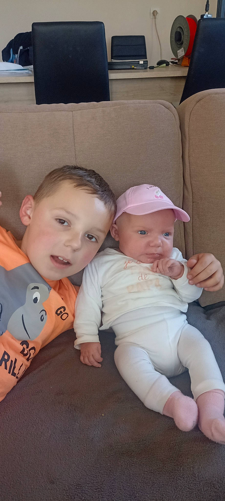 Lina participe au concours pour gagner de l'argent avec cette photo : arm, baby, baby_toddler_clothing, cheek, child, comfort, couch, eye, gesture, hairstyle, hand, happy, headwear, iris, lap, leg, person, sitting, skin, smile