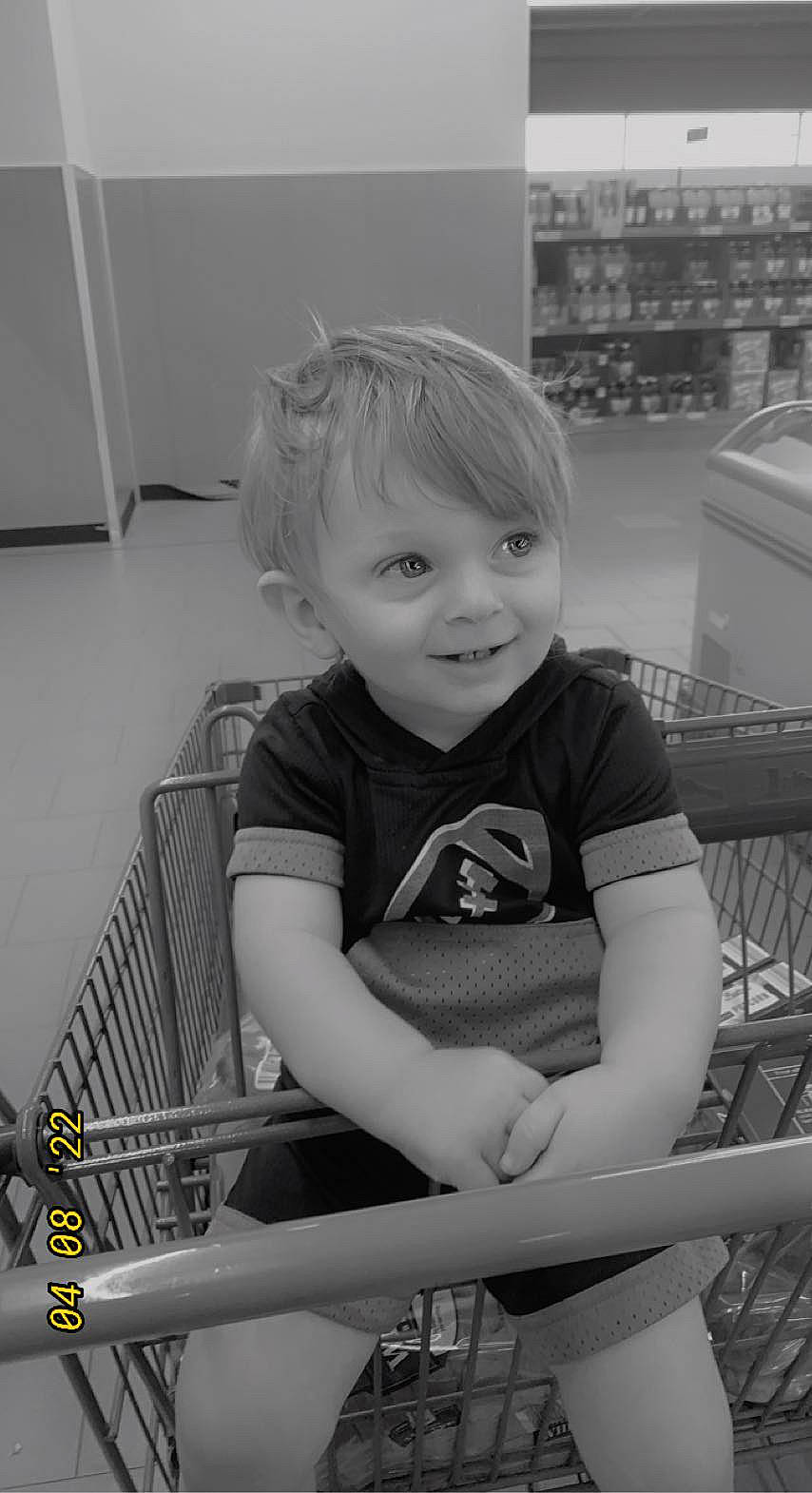 Bellamy is registered to the contest to win money with this photo: baby, black, black_and_white, child, elbow, facial_expression, fun, happy, iris, joy, monochrome, monochrome_photography, person, play, portrait_photography, shopping_cart, shorts, sitting, smile, style
