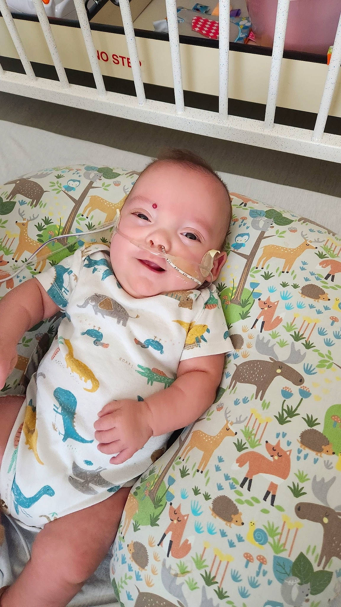 Desmond is registered to the contest to win money with this photo: baby, baby_products, baby_toddler_clothing, cheek, child, comfort, eye, face, flooring, happy, head, iris, linens, mouth, person, product, sitting, skin, smile, textile