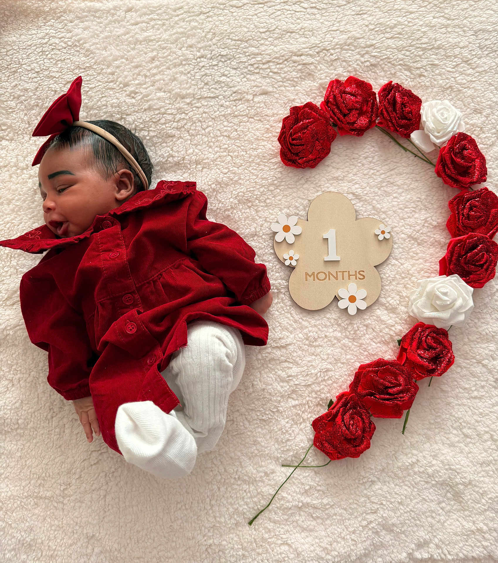 Ayana a rejoint le concours — aidez-le/la à gagner de superbes lots ! baby, infant, red_clothing, headband, bow, white_socks, blanket, flower_wreath, roses, wooden_sign, milestone, one_month, cute, soft_texture, portrait, lying_down, child, newborn, decor, celebration