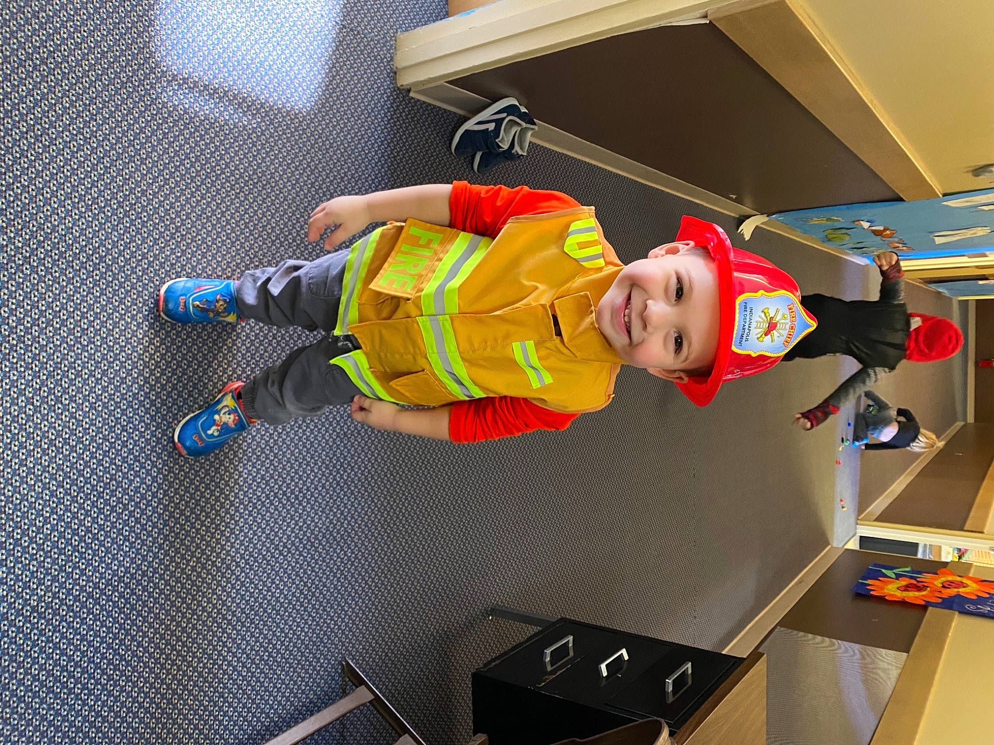 Aden is registered to the contest to win money with this photo: child, fictional_character, flooring, fun, hat, headwear, joy, orange, pattern, person, personal_protective_equipment, recreation, room, sneakers, sportswear, t_shirt, toddler, toy, walking_shoe