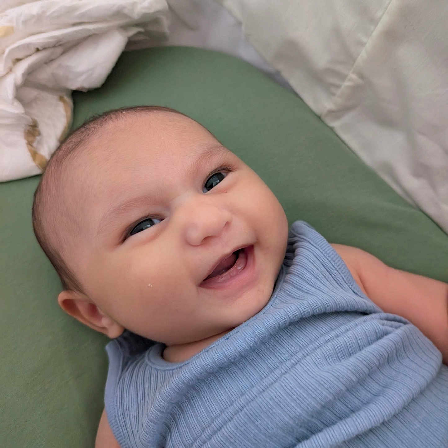 Eren joined the competition — help win amazing prizes! baby, blanket, blue_clothing, child, closeup, cushion, eyes, fabric, face, green, happy, head, indoors, infant, lying_down, mouth, person, skin, smiling, teeth
