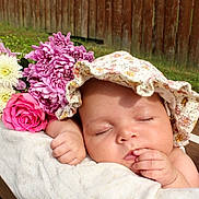 Kailani joined the competition — help win amazing prizes! baby, sleeping, flower, bouquet, pink_flower, white_flower, bonnet, wooden_crate, blanket, grass, outdoor, peaceful, infant, face, hand, nature, portrait, relaxation, cute, garden