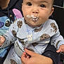 Kailani is registered to the contest to win money with this photo: baby, child, face, cream, pajamas, cookie_pattern, person, hand, clothing, hoodie, indoor, messy, cute, expression, holding, seated, closeup, skin, head, eyes
