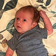 Allen joined the competition — help win amazing prizes! baby, infant, child, onesie, clothing, blanket, pattern, animal_print, face, skin, arm, hand, hair, lying_down, indoors, curious, expression, portrait, young, cute