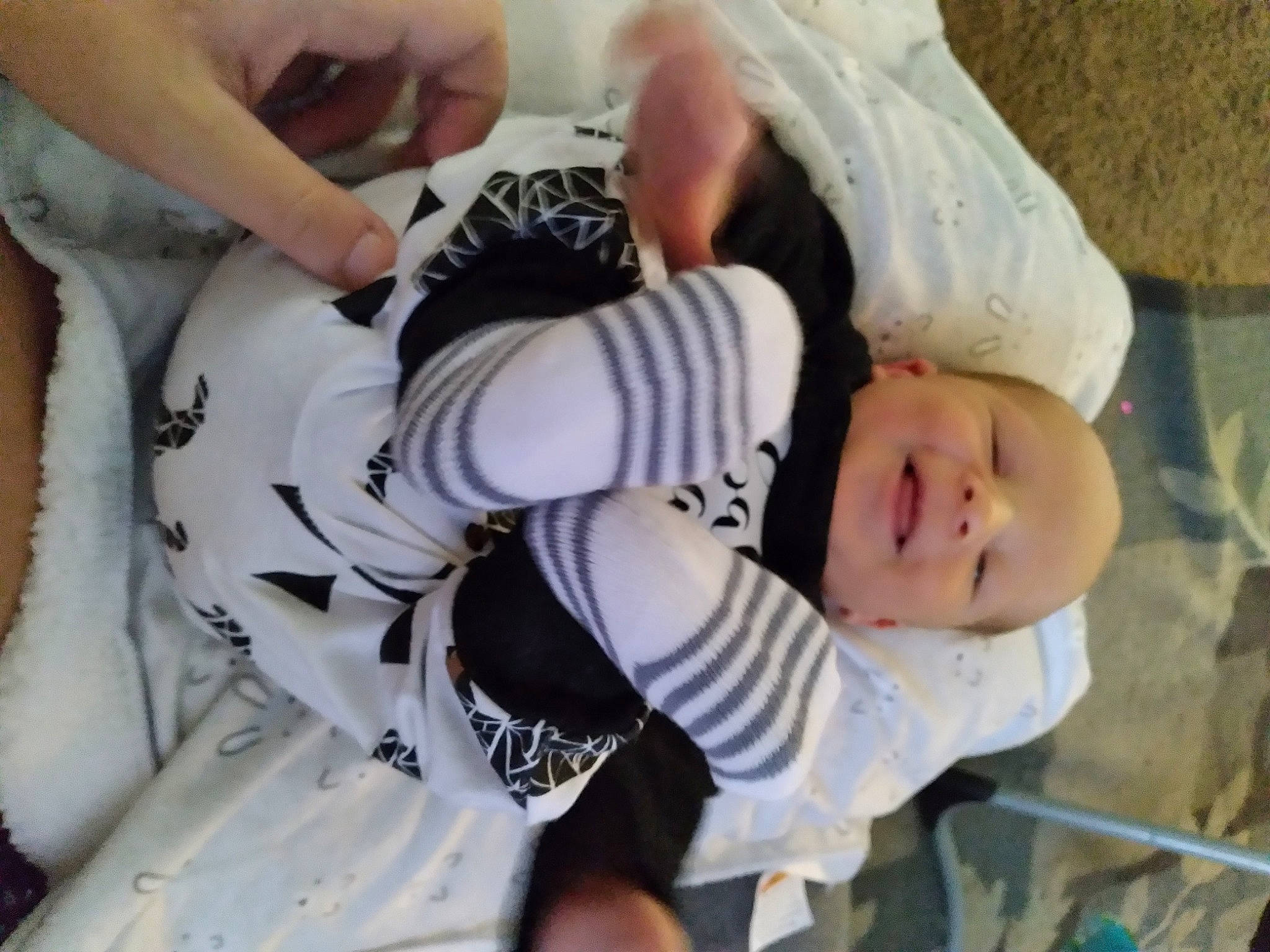 River is registered to the contest to win money with this photo: baby, baby_products, baby_toddler_clothing, chest, child, elbow, finger, gesture, glove, hand, human_body, nail, pattern, person, sleeve, sports_gear, sports_uniform, thigh, thumb, toddler