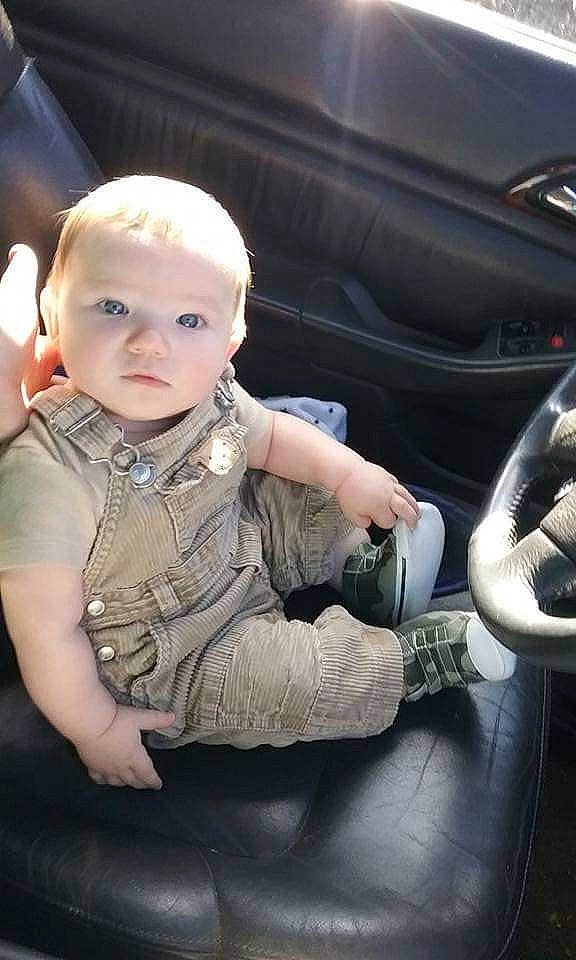 Cash is registered to the contest to win money with this photo: auto_part, automotive_exterior, automotive_lighting, automotive_tire, baby, baby_toddler_clothing, bumper, car, car_seat, car_seat_cover, child, family_car, flash_photography, leg, motor_vehicle, person, personal_luxury_car, sitting, steering_wheel, toddler