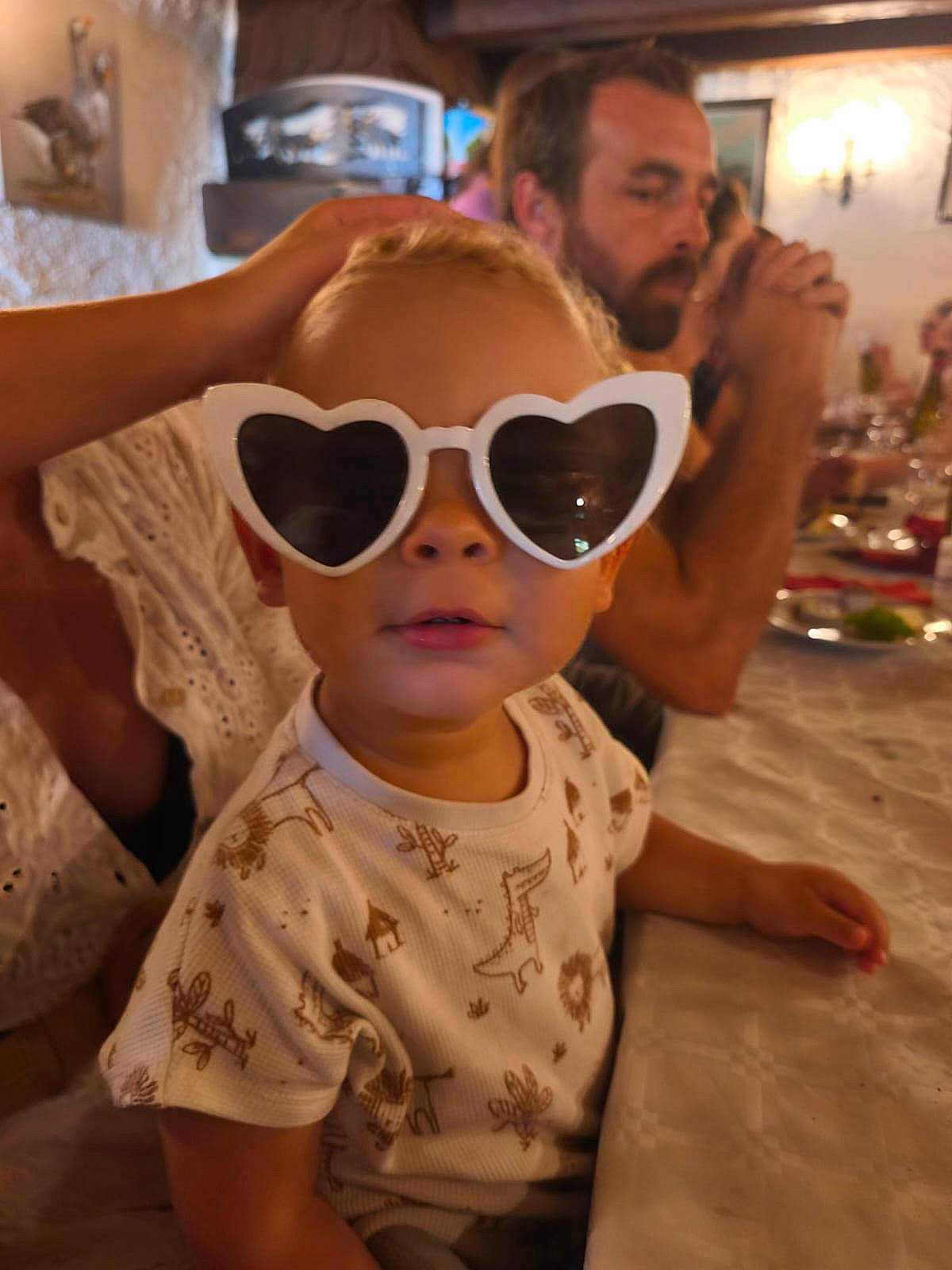 Pharell a rejoint le concours — aidez-le/la à gagner de superbes lots ! adult, beard, blurred_background, casual, child, clothing, dining, face, family, glasses, hand, heart_shaped_sunglasses, indoor, light, patterned_shirt, people, person, seated, table, toddler