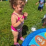 Celine is registered to the contest to win money with this photo: toddler, child, water, swimsuit, pink, grass, backyard, play, summer, splash, pool, happy, curly_hair, barefoot, outdoor, sunlight, fun, kids, toy, shoes