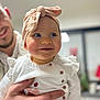 Olivia participe au concours pour gagner de l'argent avec cette photo : baby, child, smile, headband, pink, bow, hand, adult, indoor, clothing, white, buttons, face, person, portrait, happy, cute, expression, holding, blurred_background