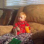 Carter joined the competition — help win amazing prizes! toddler, child, pajamas, sippy_cup, blanket, couch, window, blinds, toy, indoor, daylight, face, hair, furniture, relaxing, cozy, home, person, comfort, casual