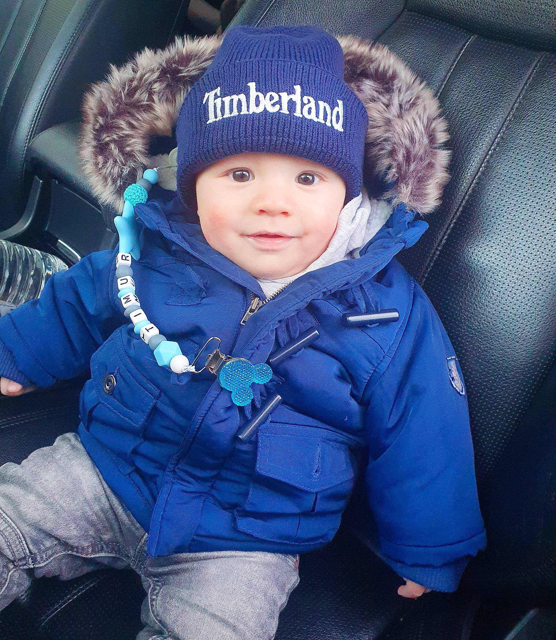 Timour participe au concours pour gagner de l'argent avec cette photo : beanie, cap, child, electric_blue, fashion_accessory, flash_photography, freezing, fun, fur, grass, happy, headgear, headwear, hood, jacket, knit_cap, person, plant, toddler, tree