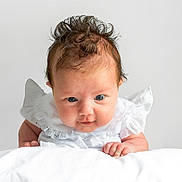Penelope joined the competition — help win amazing prizes! baby, infant, child, portrait, white_clothing, lace, blanket, curly_hair, blue_eyes, closeup, cute, soft_light, studio, neutral_background, expression, hands, skin, face, person, newborn